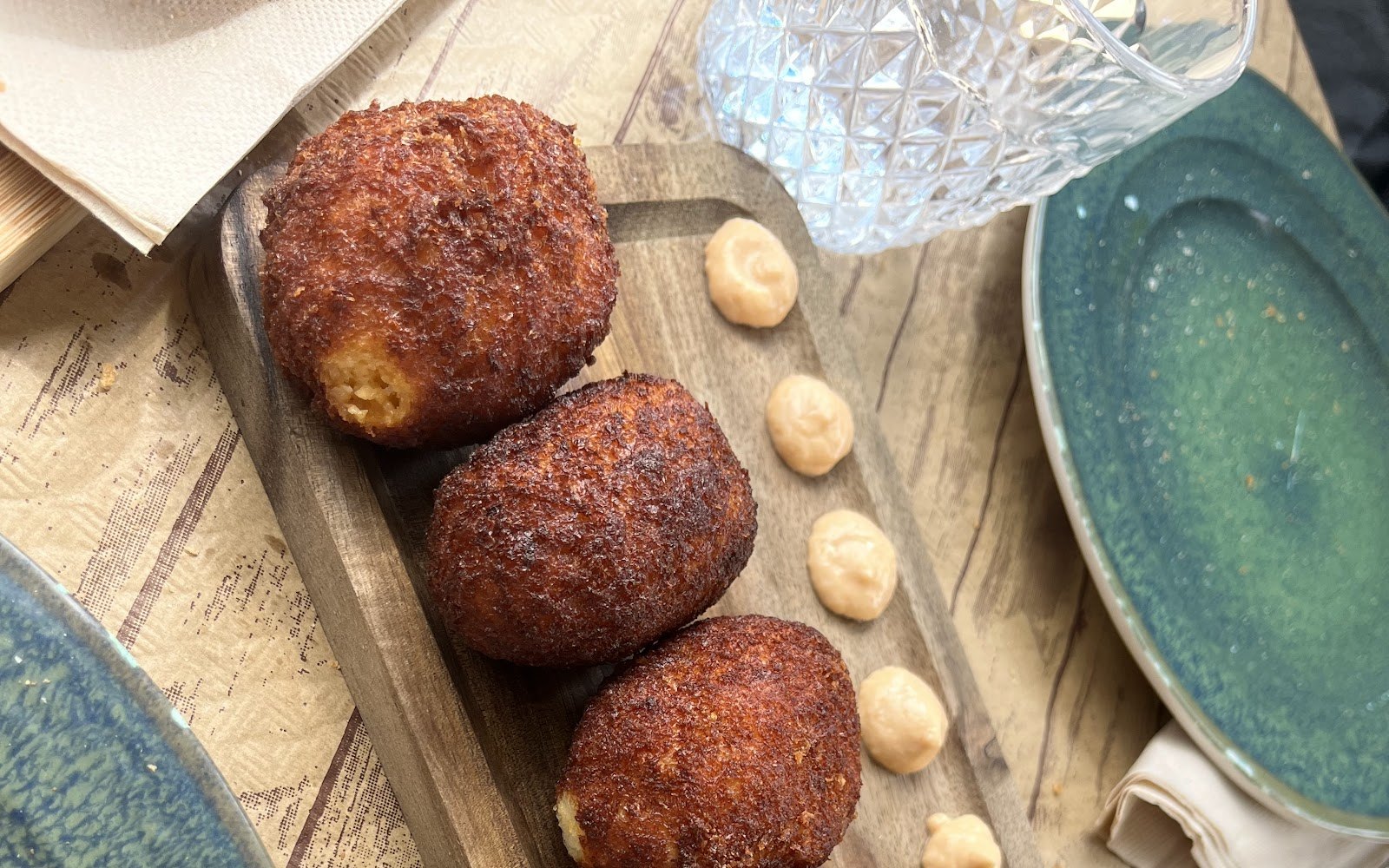 Croquetas caseras doradas sobre tabla de madera